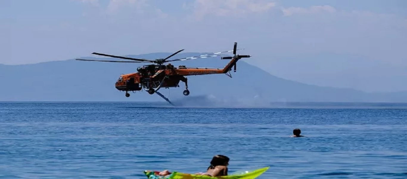 Φωτιά στα Βίλια: Λουόμενοι απολαμβάνουν το μπάνιο τους ενώ ελικόπτερα φορτώνουν νερό (φώτο)